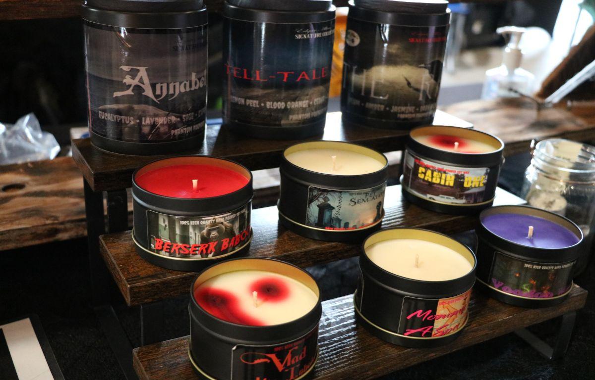 A table filled with vibrant, round candles in various colors and patterns, set up for sale.
