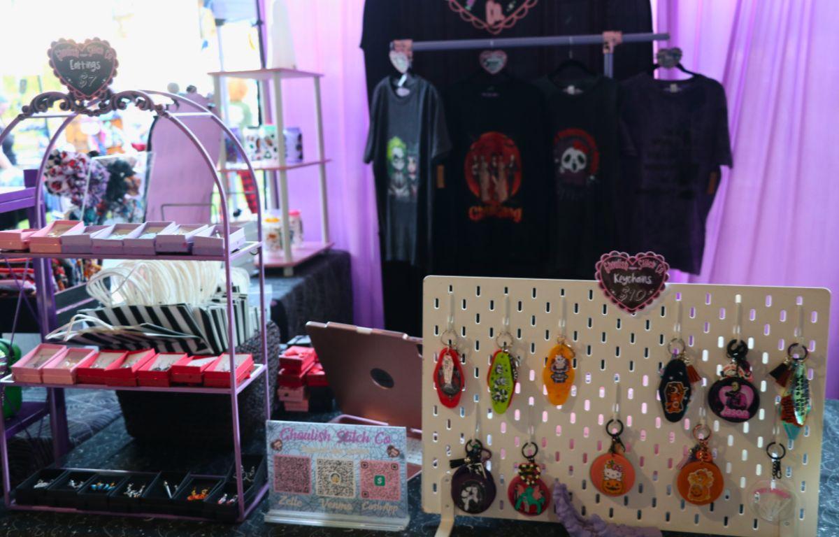 A vendor booth filled with a wide variety of craft goods, from jewelry to candles and decor.