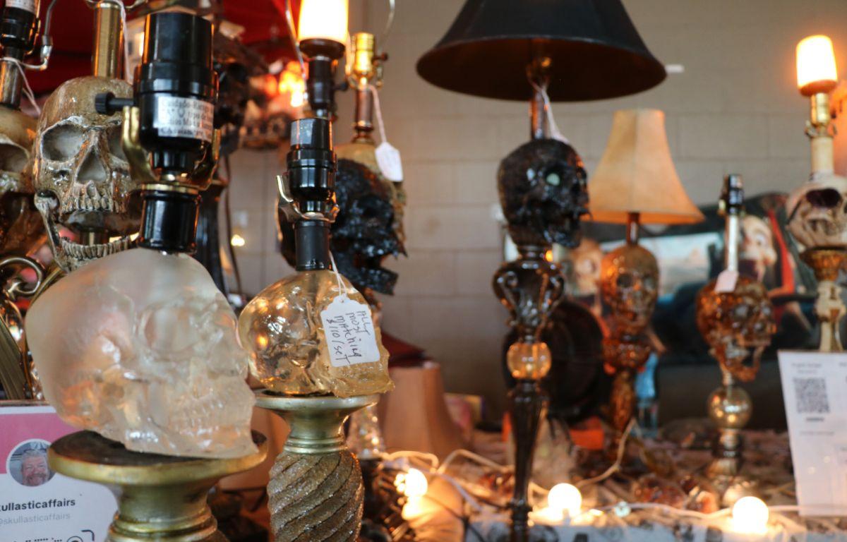 Decorative lamps featuring skull designs illuminated on a vendor's display table.