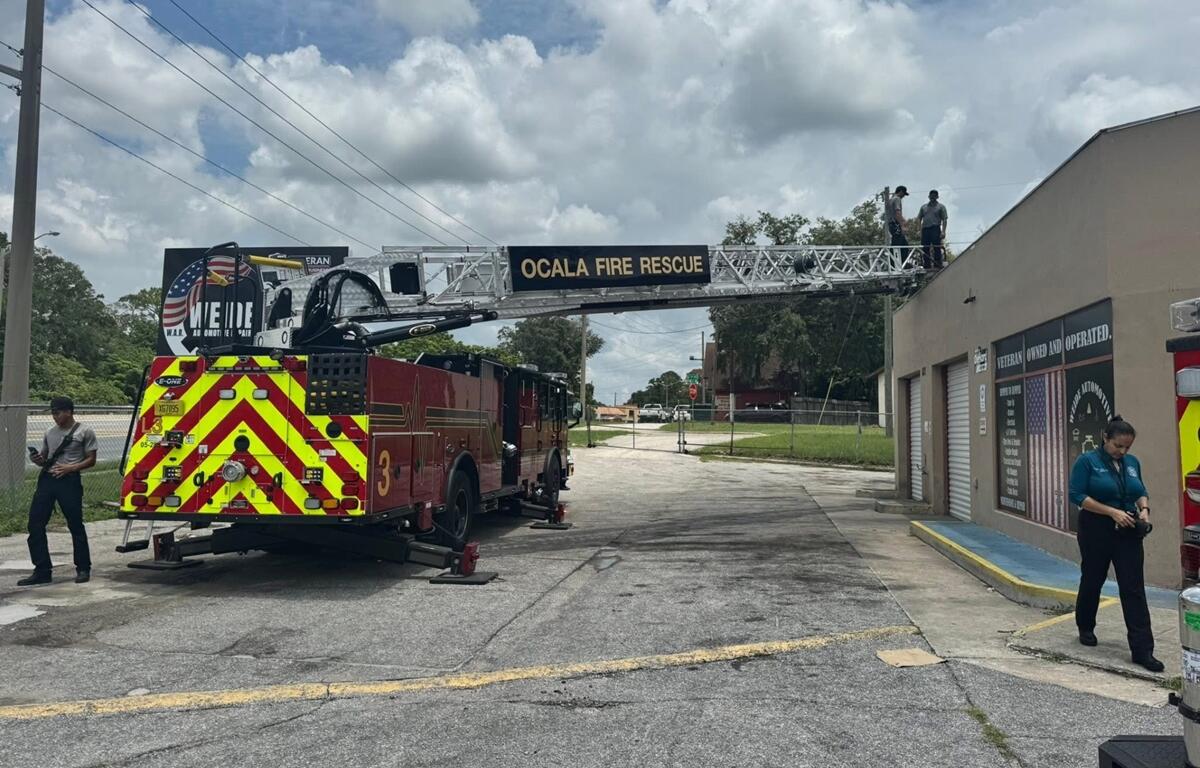 Ocala Fire Rescue ladder truck extended to roof of tan building during firefighter training