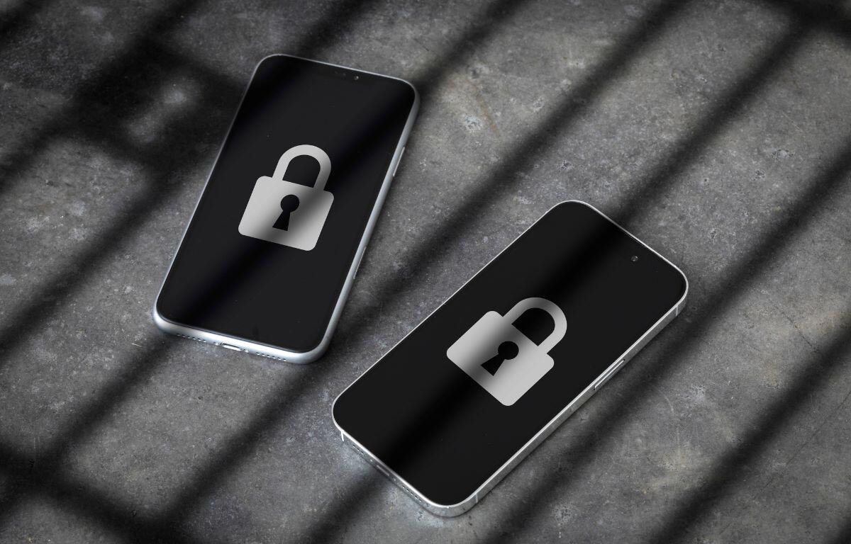Two smartphones with lock icons on their screens, symbolizing security or data protection, lying on a surface with shadow lines.