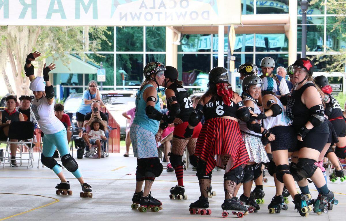 Pack of skaters clustered tightly mid-jam.
