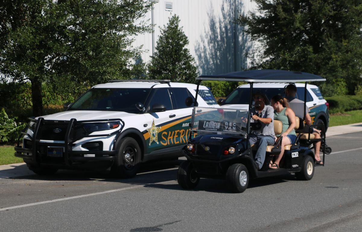 Shuttle bus transporting attendees with jeeps and vehicles parked nearby.