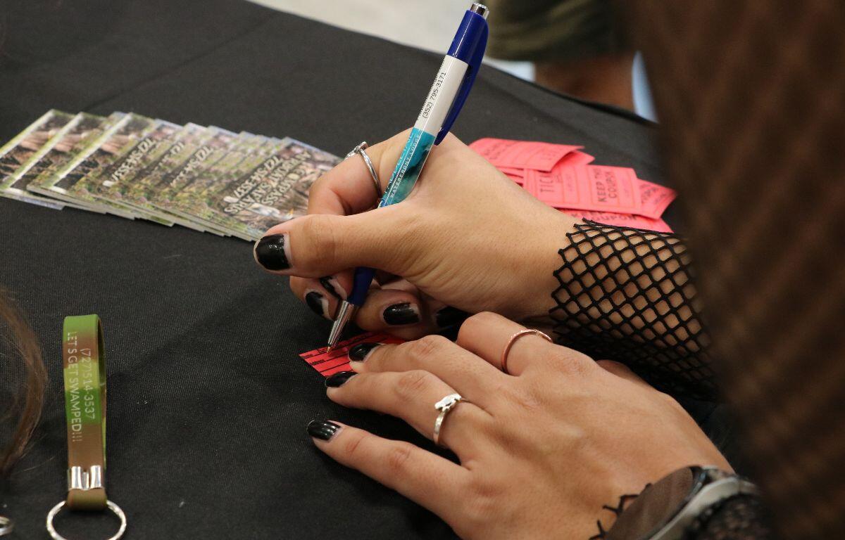 Close-up of a guest writing on a raffle ticket.
