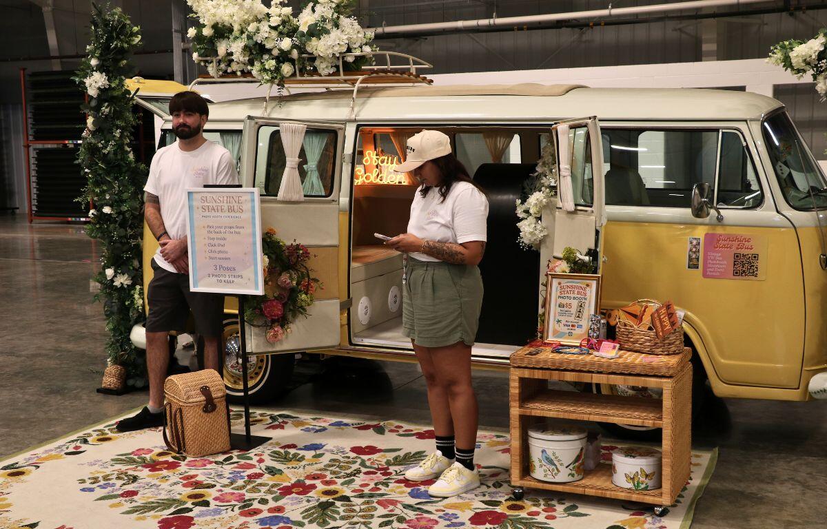 Retro yellow-and-white Volkswagen bus set up as a photo booth with props and decorations.
