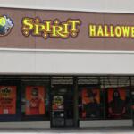 Exterior view of a Spirit Halloween store with a bright sign above the entrance.