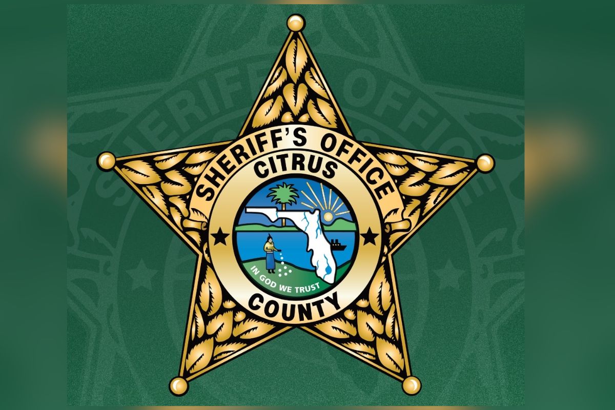 A gold badge and in the center, writing and an insignia against a green background.