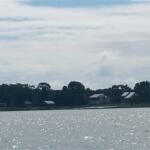 View of Lake Weir with houses and trees along the shoreline under a partly cloudy sky
