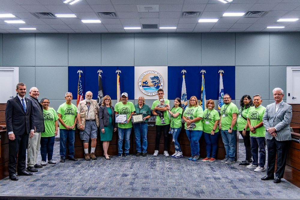The Marion County Commission poses with Miguel Sanchez (left of center holding certificate), and members of the Marion Oaks Community Beautification Crew at the Aug. 19 BCC meeting.