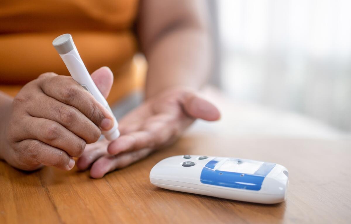 Close-up of a person using a glucose monitor to check blood sugar levels.