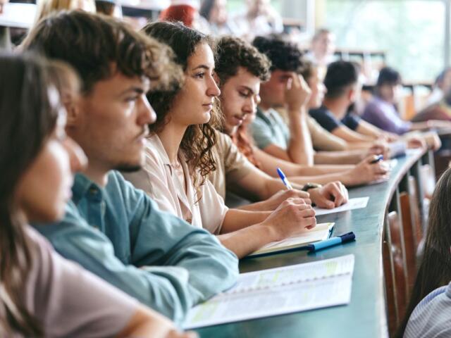 A group of students writing notes in class.