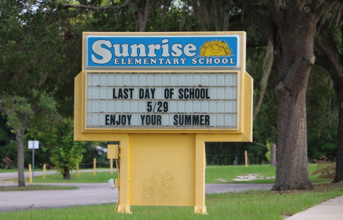 ChatGPT said: A yellow marquee sign in front of Sunrise Elementary School displays the message: "LAST DAY OF SCHOOL 5/29 ENJOY YOUR SUMMER." The sign is set against a backdrop of trees and a quiet road, indicating a peaceful school environment.
