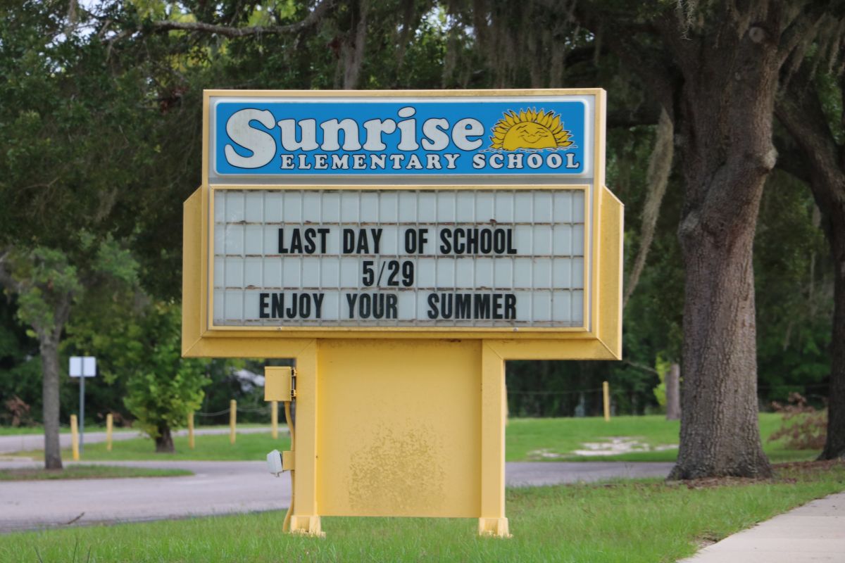 ChatGPT said: A yellow marquee sign in front of Sunrise Elementary School displays the message: "LAST DAY OF SCHOOL 5/29 ENJOY YOUR SUMMER." The sign is set against a backdrop of trees and a quiet road, indicating a peaceful school environment.