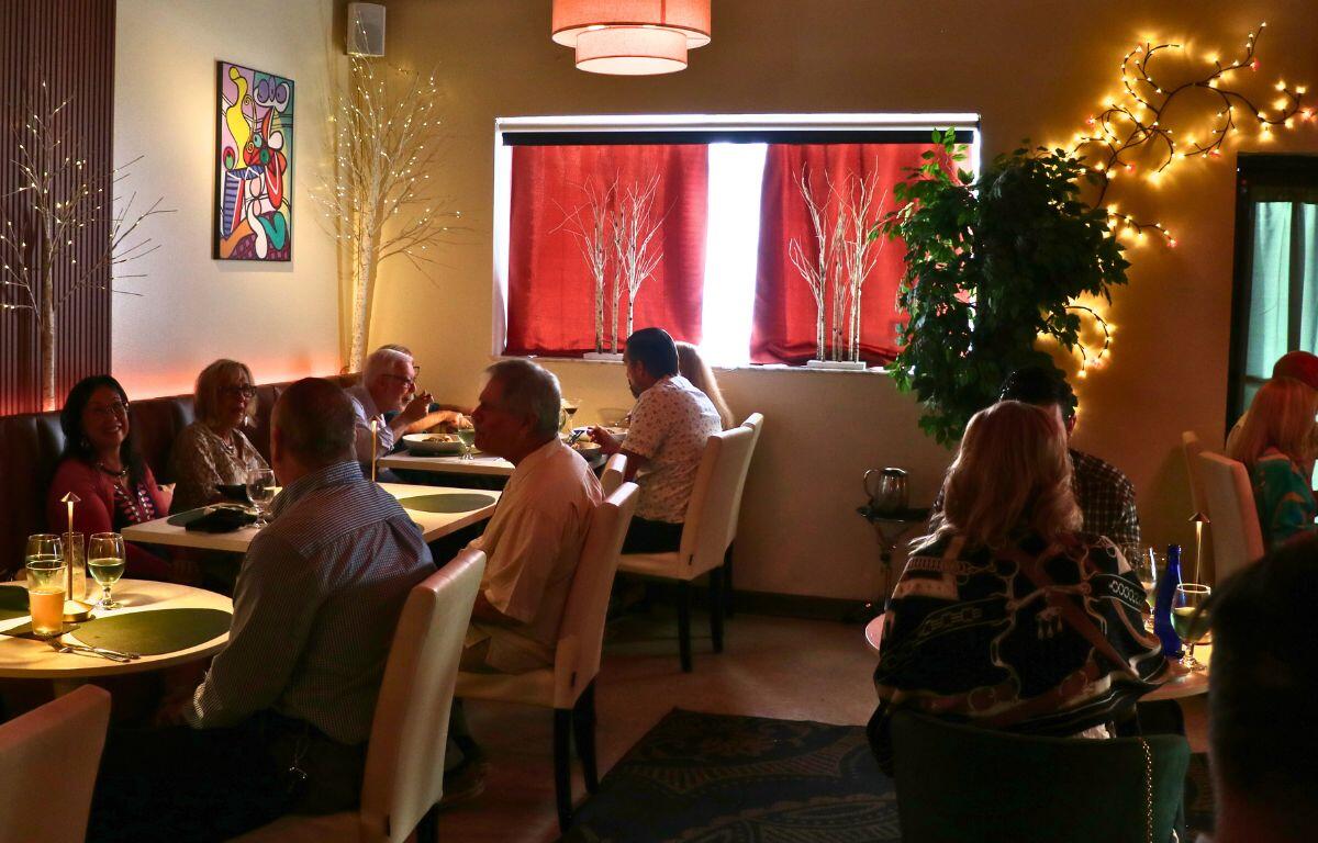 Dining room with set tables, red chairs, and floral centerpiece.