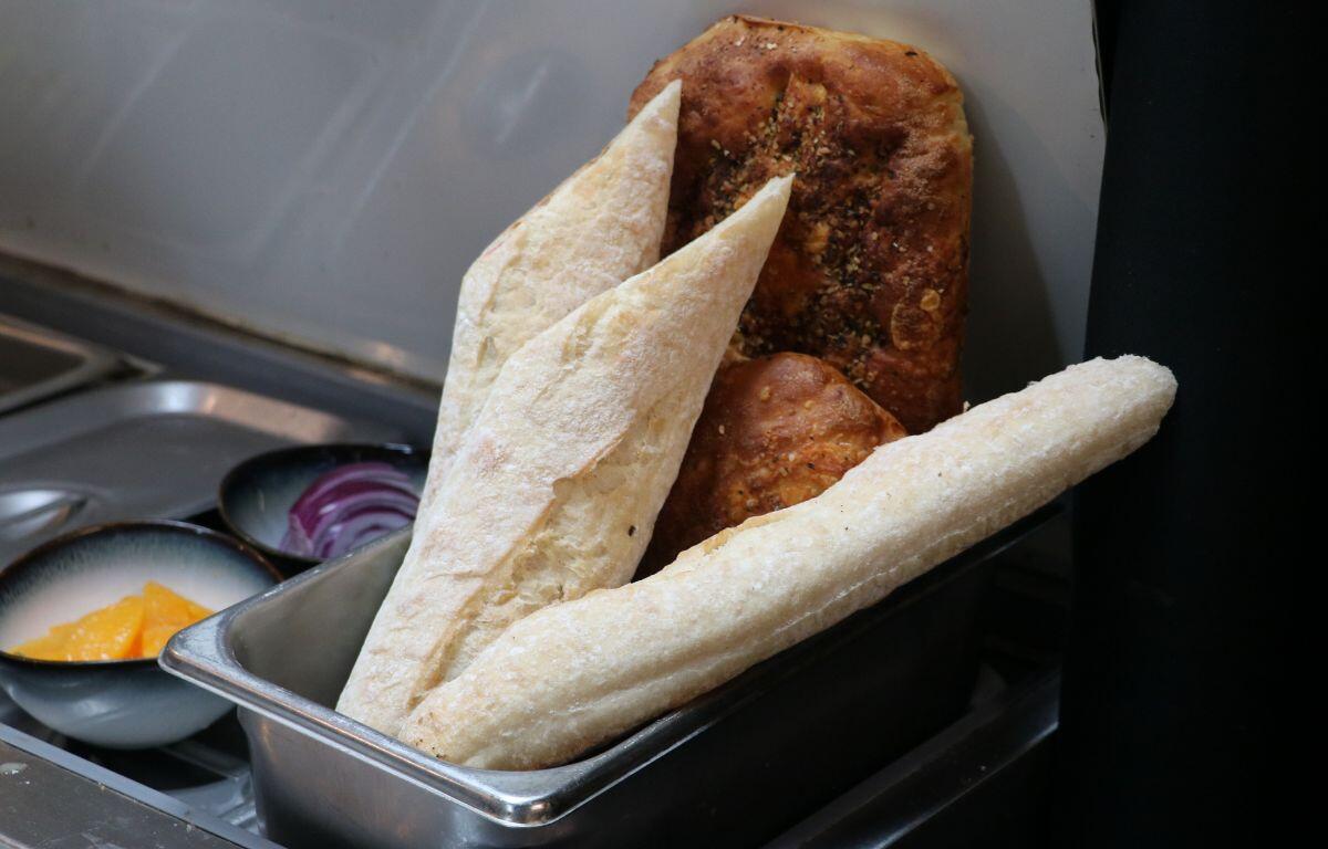 Bread roll with flatbread resting in a metal tin.