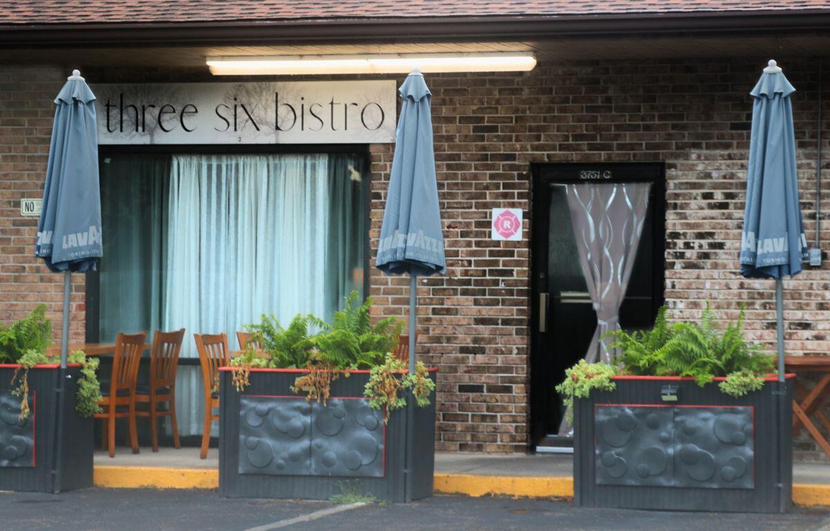 Exterior of the restaurant with blue curtains and patio seating.