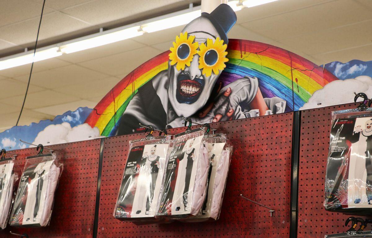 Display of horror-themed costumes featuring Terrifier's Art the Clown at Spirit Halloween.