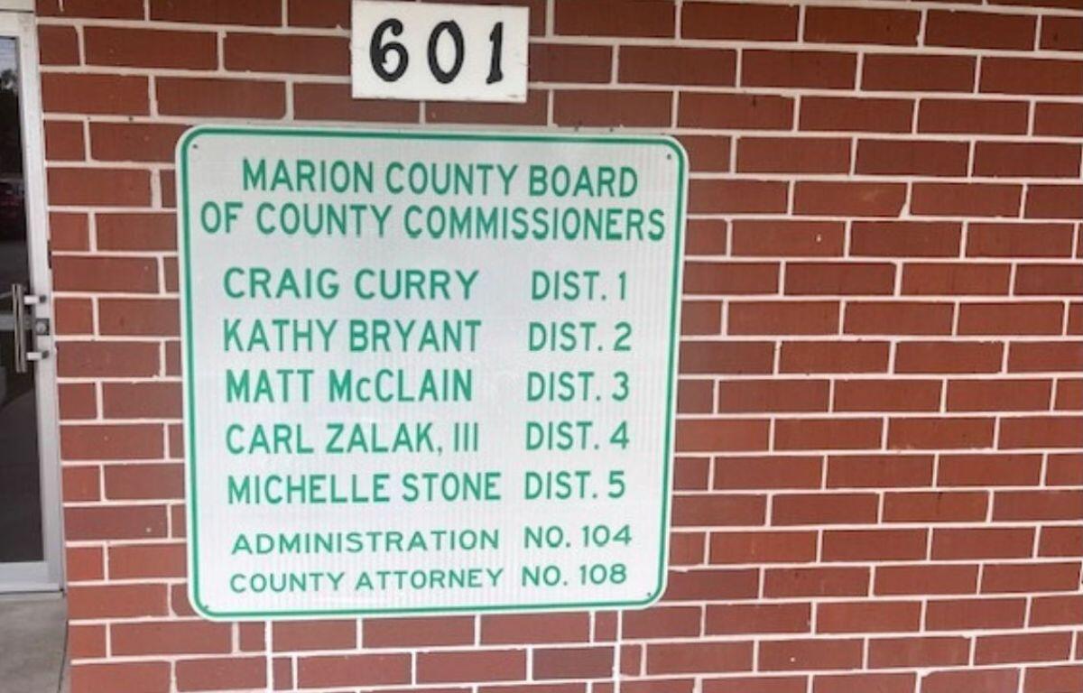 Glass door to the left, bring wall with a numbers on a placard above large placard with letters and numbers.
