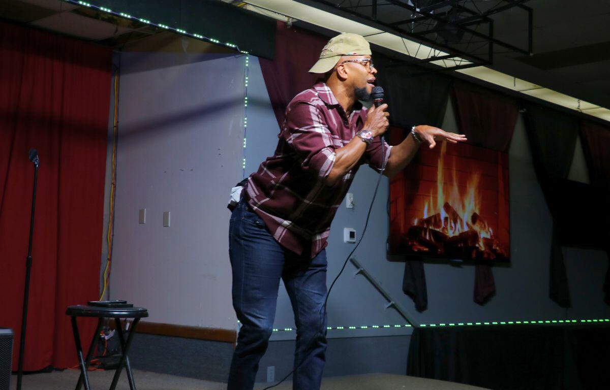 Headliner Vince Taylor performs animated stand-up, engaging the audience with lively gestures.