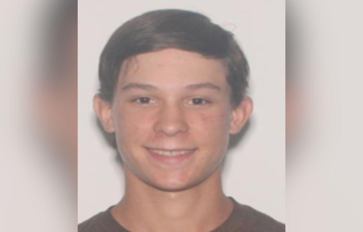 Headshot of 17-year-old Caden Speight, smiling, with short brown hair, wearing a dark shirt, against a plain light background.