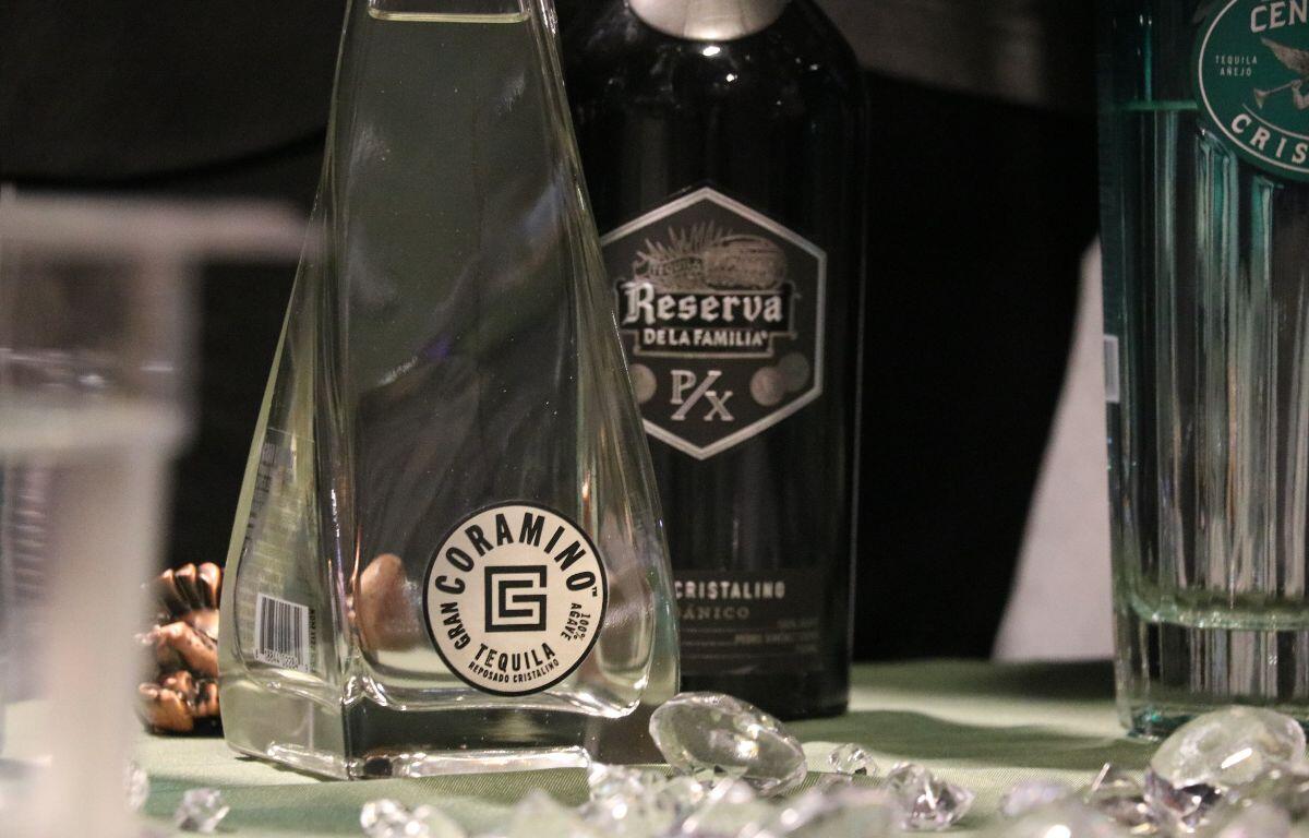 A table features two bottles of alcoholic beverages with diamond decorations scattered around the table.