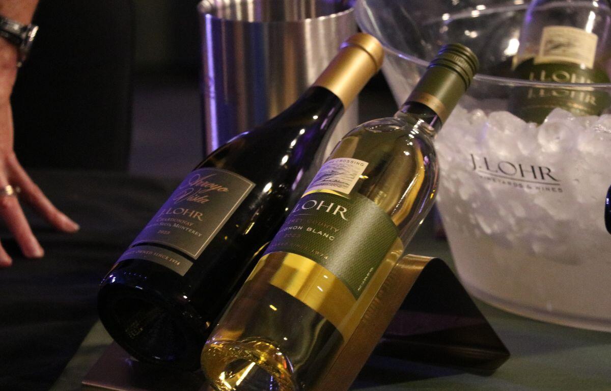 Two J. Lohr alcohol bottles are displayed on a table with a green tablecloth. In the background is a bucket of ice with more alcohol bottles in it.