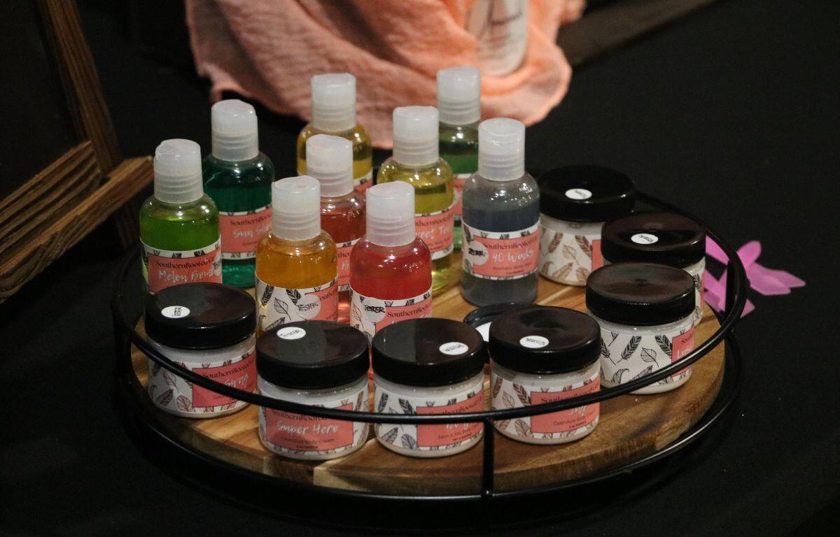 Various self-care products are set on a circular wooden display table.