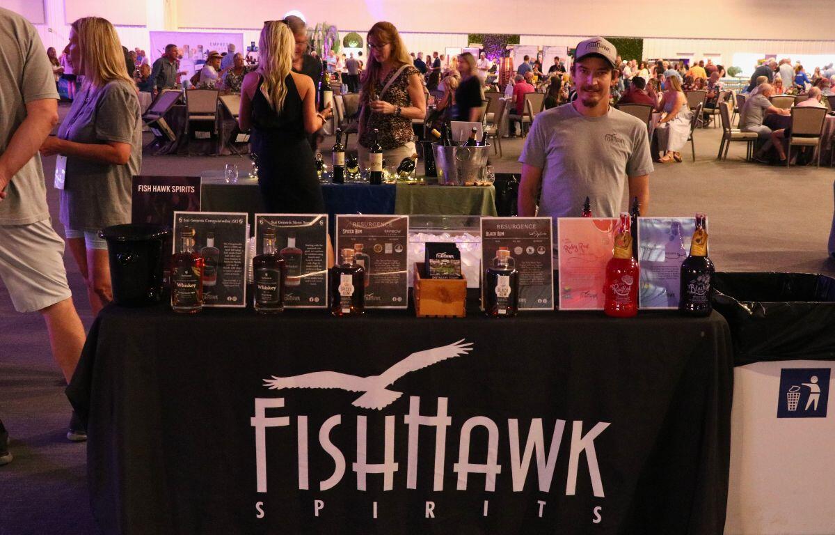 A booth for FishHawk Spirits displays varieties of alcoholic beverages.