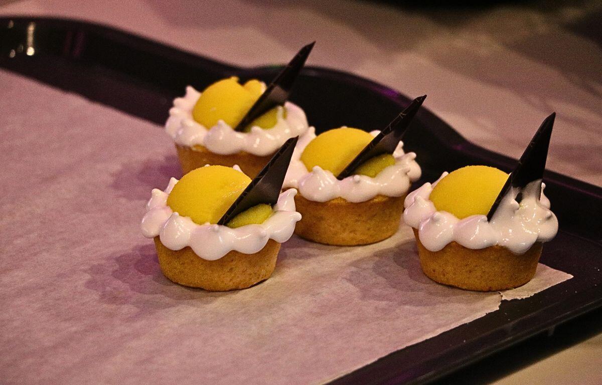 Four deserts are displayed on a black tray on a baking sheet.