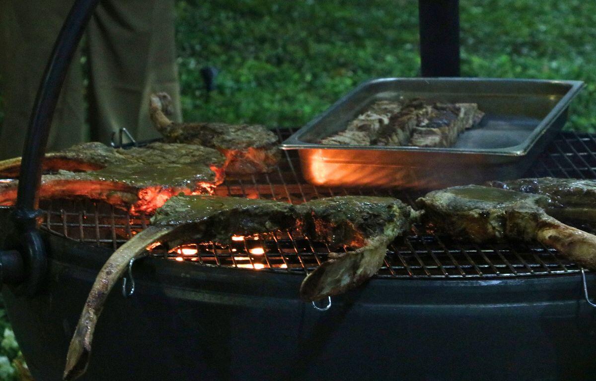 Tomahawk steaks grilling on a suspended Cowboy Cauldron.
