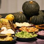 Gourds sit in the background with dishes laid out in front.