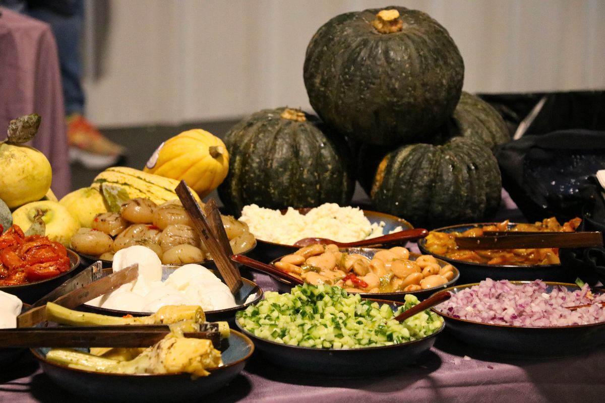 Gourds sit in the background with dishes laid out in front.