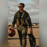 Actor in flight gear walking on runway, promotional still from Top Gun: Maverick.