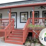 A historic house turned into a coffee shop features a sign in a window reading, "Cattle Dog Coffee Roasters." The sign has a graphic of a dog roaster a pot over a fire. A graphic in the foreground features a plate with a fork take a piece out of a blue letter. Green and blue letters read, "352EATS."