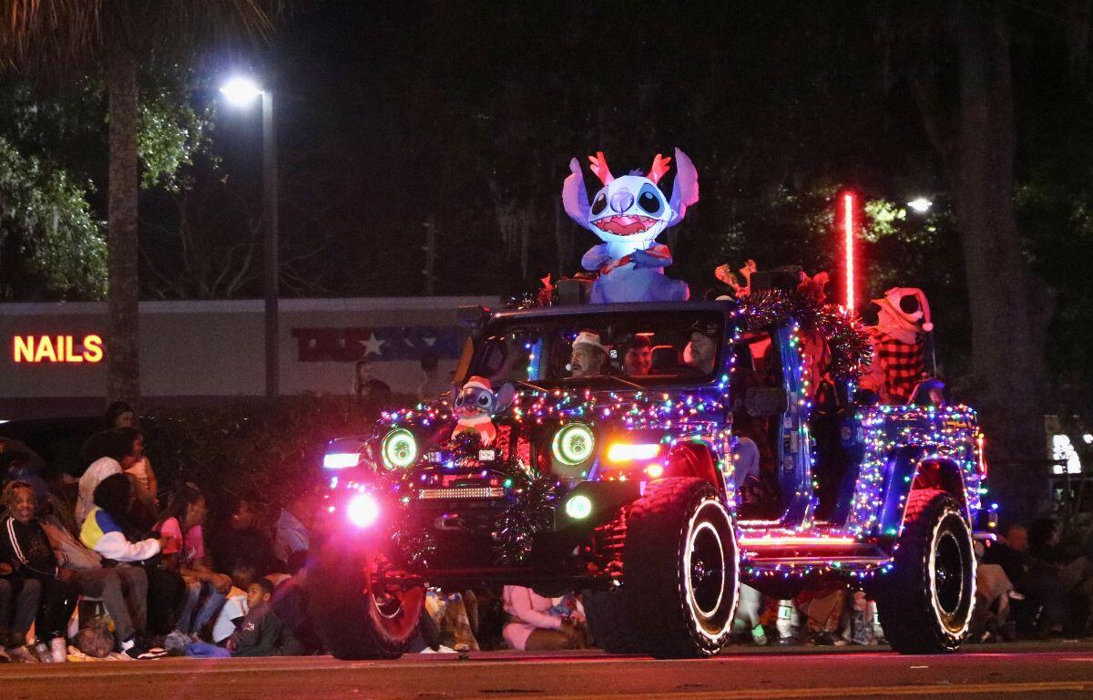 A car decorated in Christmas lights featured multiple inflatables with Stitch as the centerpiece on top.