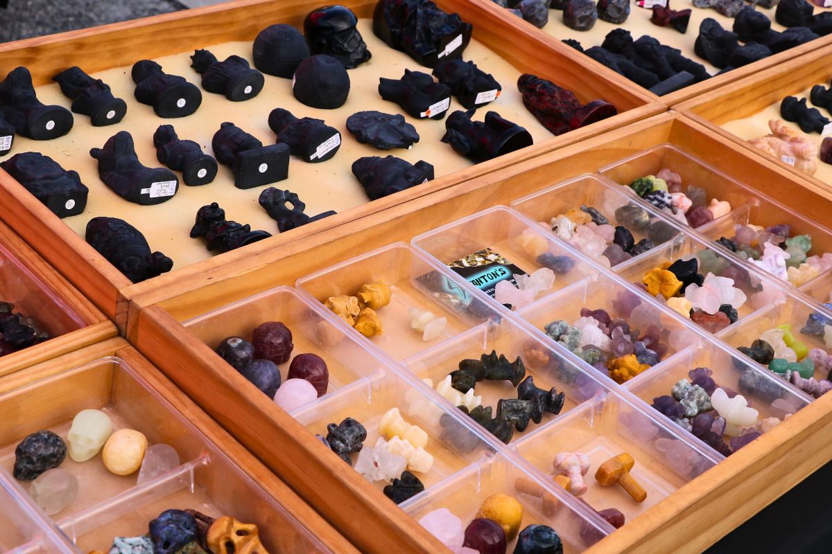 A wooden case displays small trinkets stored in clear boxes.