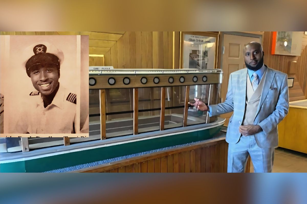 A portrait of a man in a uniform on the left, with a model of a glass-bottom boat, with a man in a blue suit standing to the right, with a white wall in the background, with an open door on the far right.