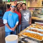 Employees in a pizzeria serve fires, chicken and pizza during a celebration event.
