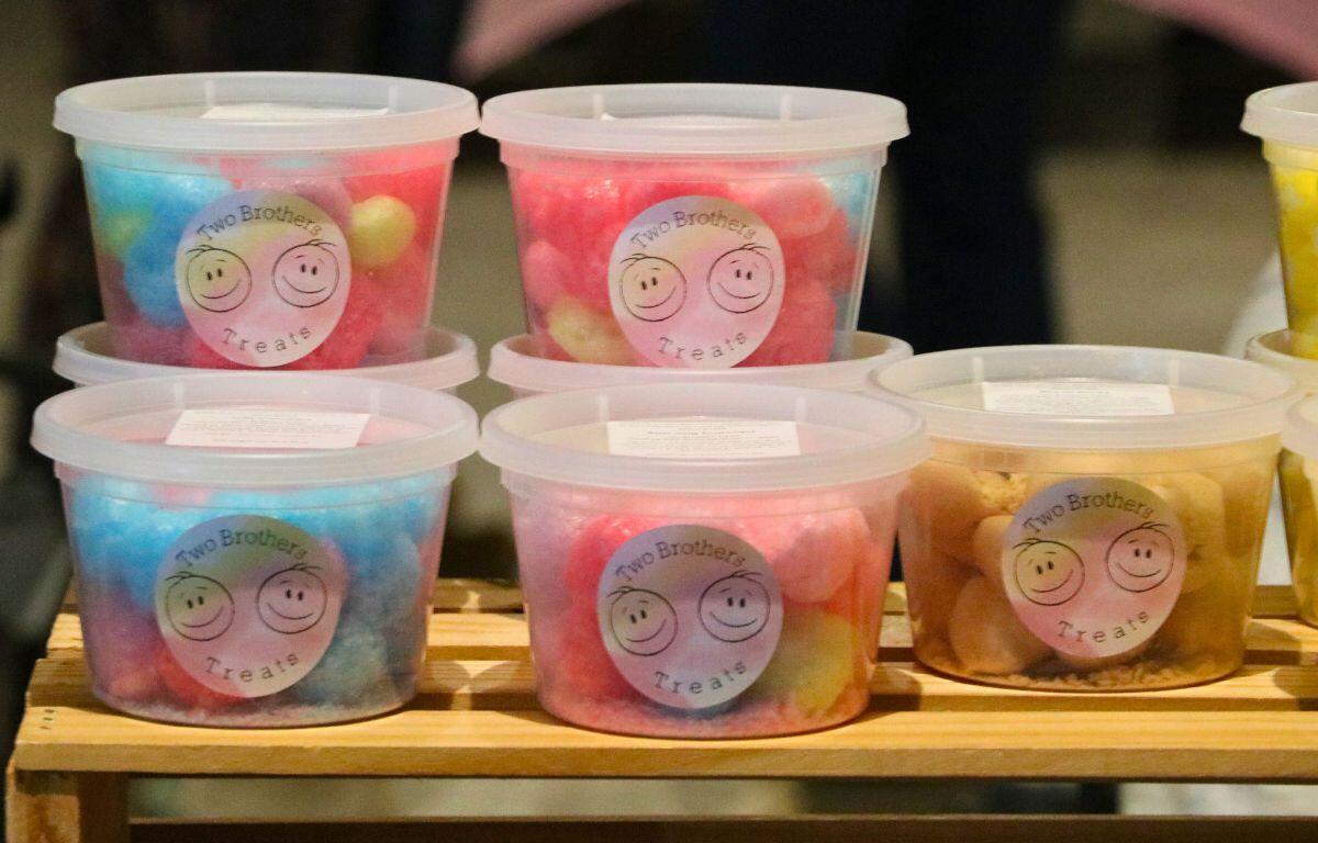 Containers of colorful treats sit on a wooden shelf. A label on the containers read, "Two Brothers Treats."