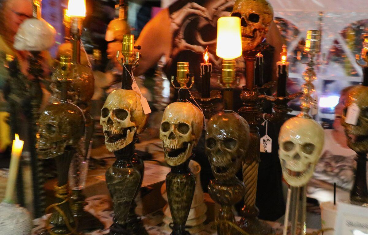 Elegant lamps with skull heads on them are displayed together on a table.