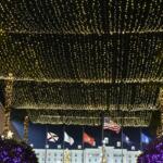 A illuminated ceiling of Christmas lights hanging overhead.