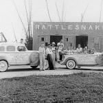 A black-and-white photograph of a rattlesnake canning factory with workers posed outside.
