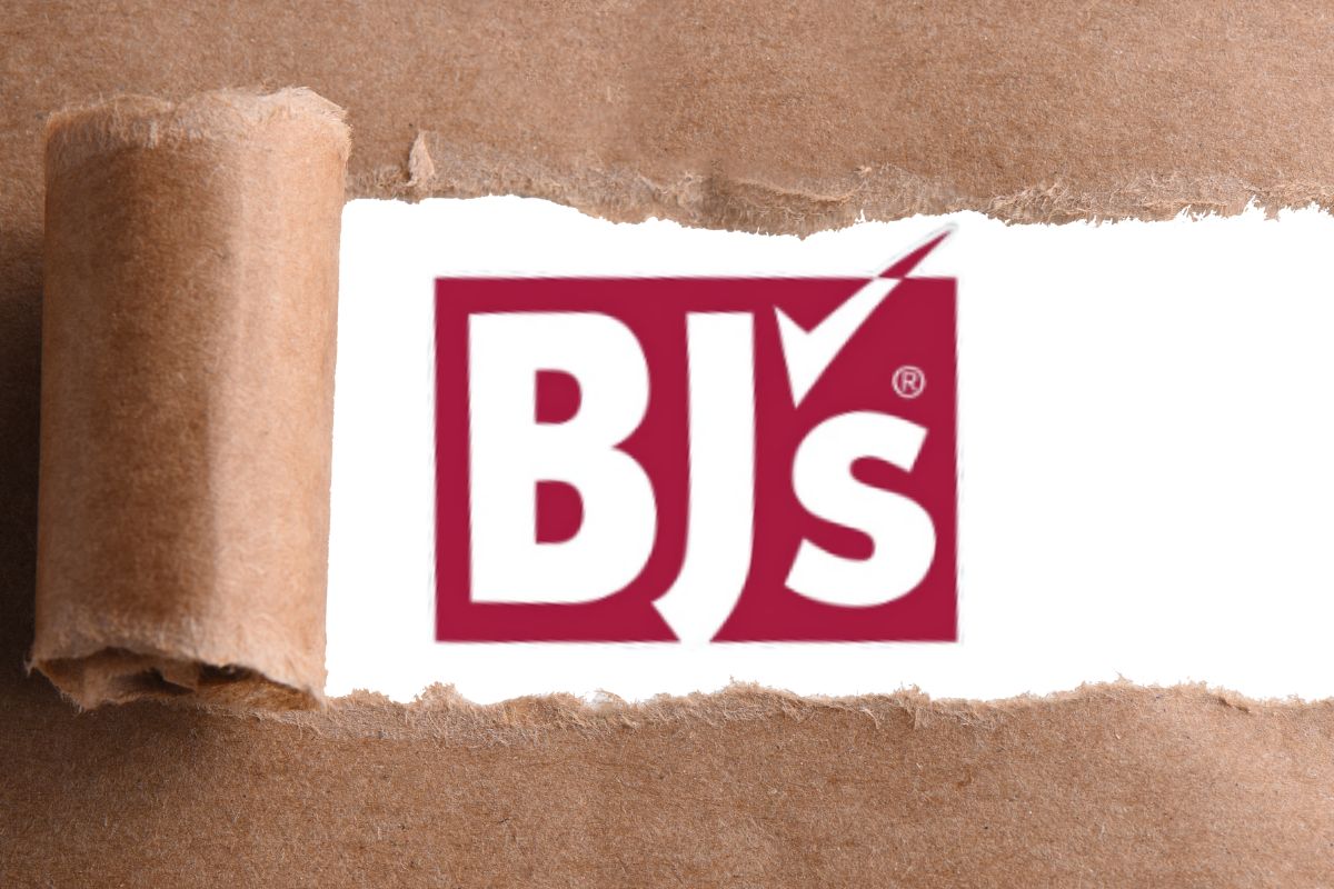 A red logo that reads, "BJs" with a checkmark as a apostrophe on a white backdrop with brown paper ripping up to reveal the logo and white background.