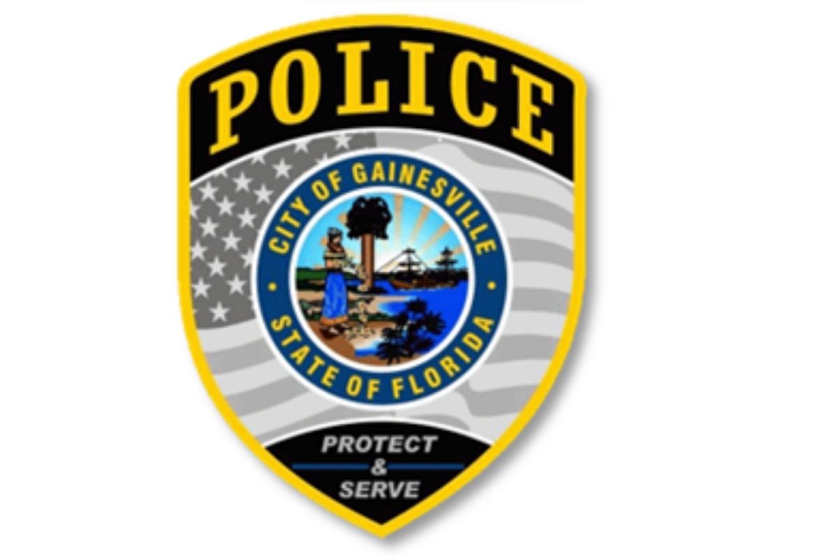 A badge with multiple colors, an insignia with an image and writing on it, and an American flag and writing within the body of the badge