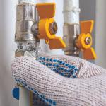 workers gloved hands working on natural gas line