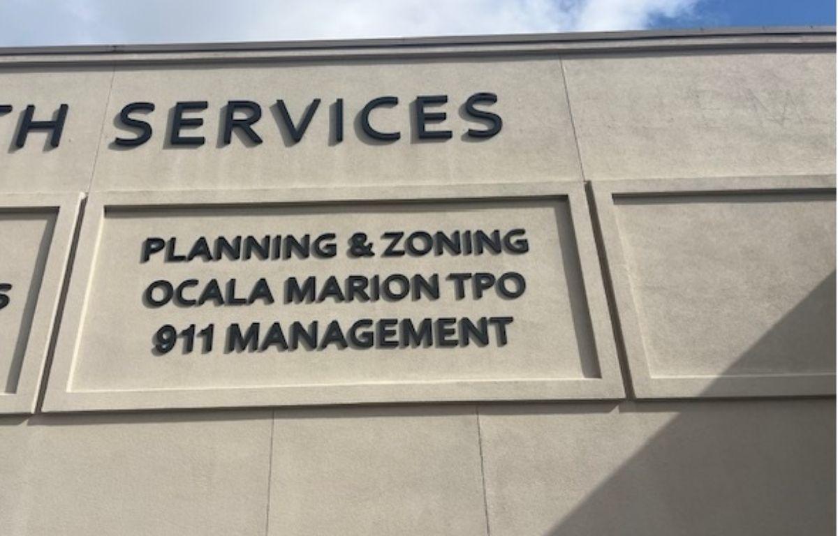 Beige facade of building with brown lettering.