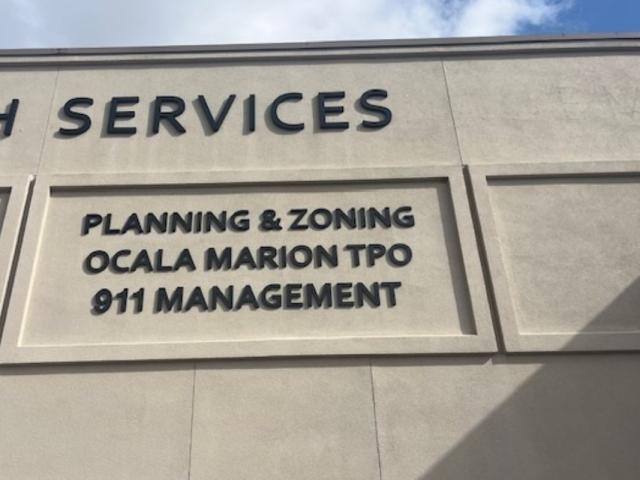 Beige facade of building with brown lettering.
