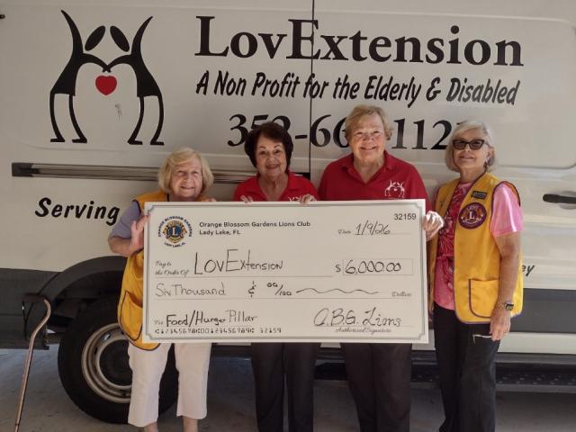 Orange Blossom Gardens Lions Club members present a donation check to LovExtension