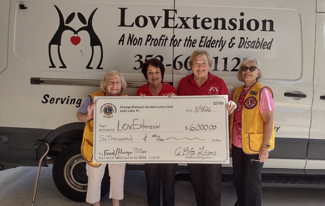 Orange Blossom Gardens Lions Club members present a donation check to LovExtension