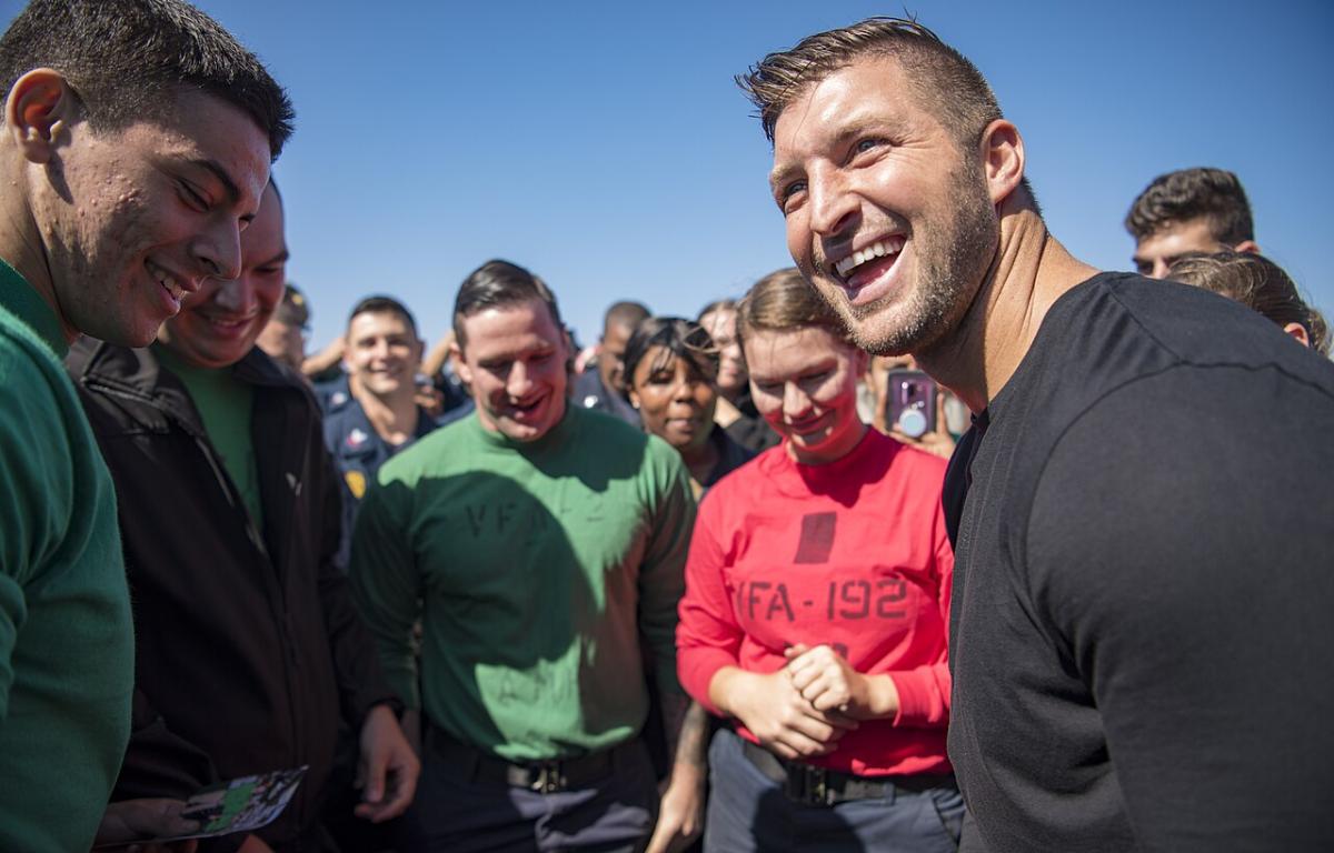 Tim Tebow interacts with Sailors on the flight deck of Nimitz-class aircraft carrier USS Carl Vinson (CVN 70) during a visit to the ship.